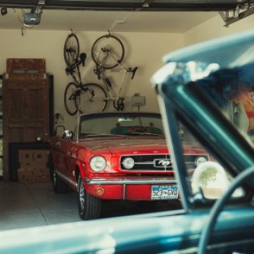 Garage with bikes hanging above a parked mustang